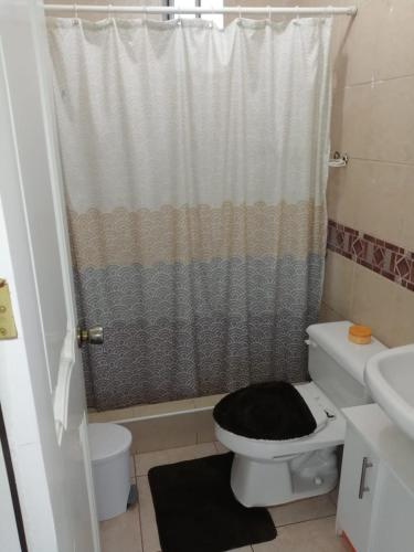 uma casa de banho com um WC e uma cortina de chuveiro em Arenys IV em Tonsupa