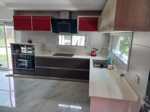 a kitchen with red and black cabinets and a sink at Casa en Ybarlucea para familia hasta 7 personas in Ybarlucea