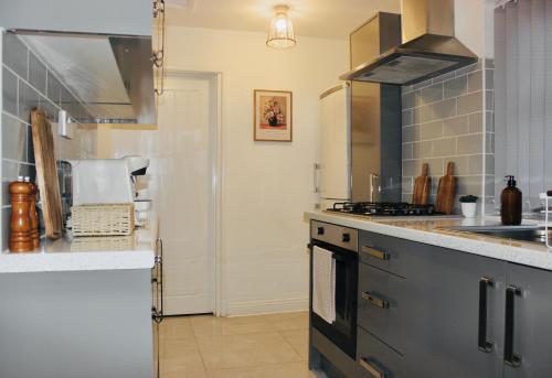 uma cozinha com um lavatório e um fogão forno superior em Chic & Cushy 3 Bed House, short and long term em Birmingham