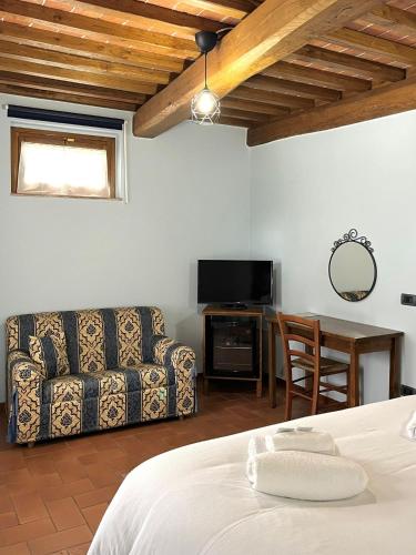 a room with a bed and a couch and a table at Sibolla Holidays in Altopascio