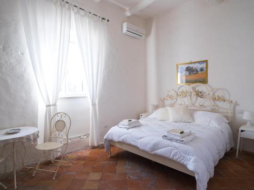 a white bedroom with a bed and a window at Ponteronico Resort in Sessa Aurunca