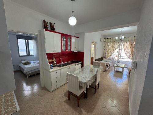 a kitchen and living room with a table and a sink at Taulant in Sarandë