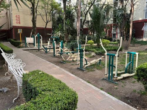 a park with a white bench and some trees at Hermoso Descanso en Coyoacán in Mexico City