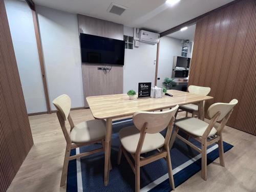 a dining room with a wooden table and chairs at Ratchadadome hostel in Bangkok