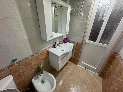 a bathroom with a toilet and a sink and a shower at Taulant in Sarandë