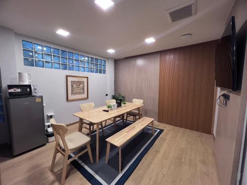 a dining room with a table and a refrigerator at Ratchadadome hostel in Bangkok