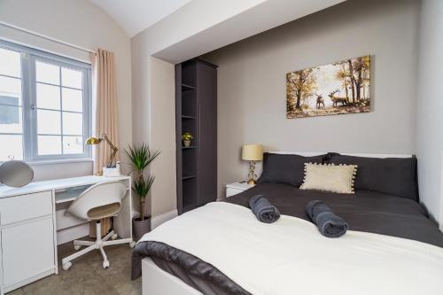 1 dormitorio con cama blanca y escritorio en Dublin Airport Homestay, en Dublín