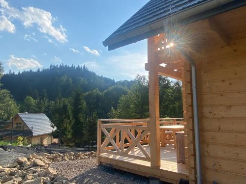 een houten hut met een terras met uitzicht op een berg bij Babiogórskie klimaty in Zawoja