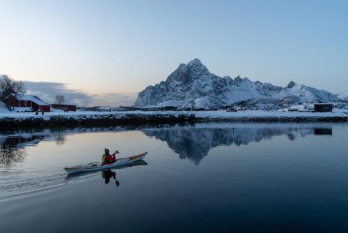 a couple of people in a canoe in the water at Skårungen - Hotel, Cabins and Camping in Kabelvåg