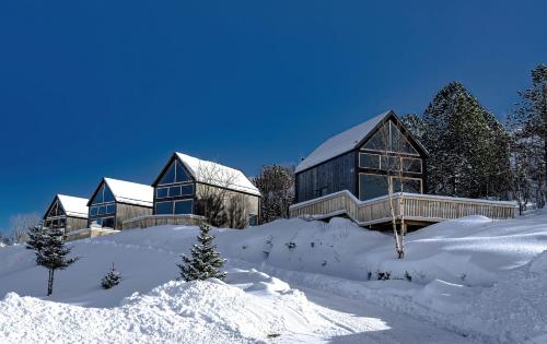 a building in the snow with snow covered ground at Skårungen - Hotel, Cabins and Camping in Kabelvåg