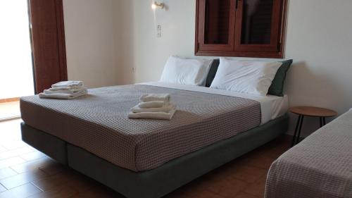 a bedroom with a bed with towels on it at Maria Apartments in Pefki