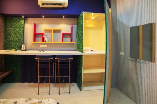 a bathroom with a counter with stools and a sink at Ramashray Premium Studio Apartments in Kanāria