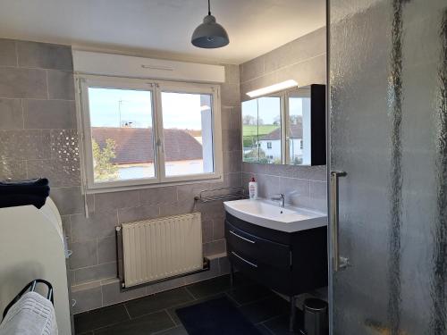 a bathroom with a sink and a window at La fleur du soleil in Trouville-sur-Mer