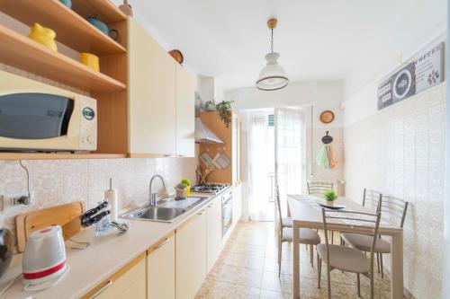 eine Küche mit Spüle und Tisch mit Stühlen in der Unterkunft 147- Ca' da Lice nel centro di Sestri Levante, 5 minuti Baia del Silenzio, Mare e Spiaggia in Sestri Levante