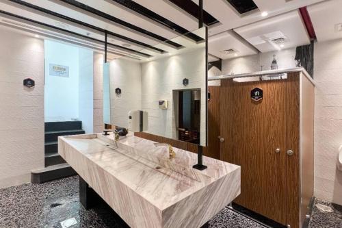uma casa de banho com um lavatório grande e um espelho grande em Beautiful Studio Apartment in Bayz Tower - near Downtown Area em Dubai