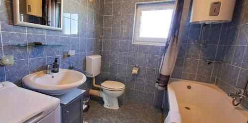 uma casa de banho com um lavatório, um WC e uma banheira em Bright & Cozy Medulin em Medulin