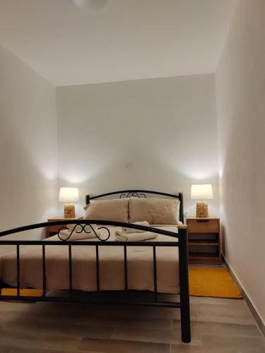 a bedroom with a bed with two lamps on it at Apartments and pool Luminous in Pula