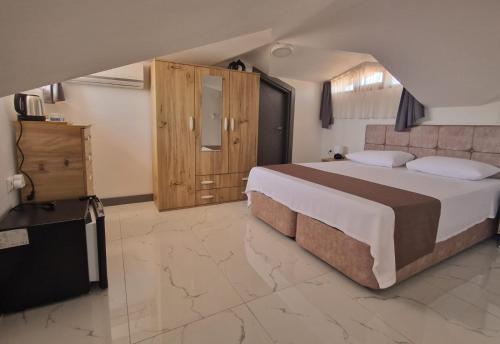 a bedroom with a large bed and a television at @Home Dalyan in Dalyan