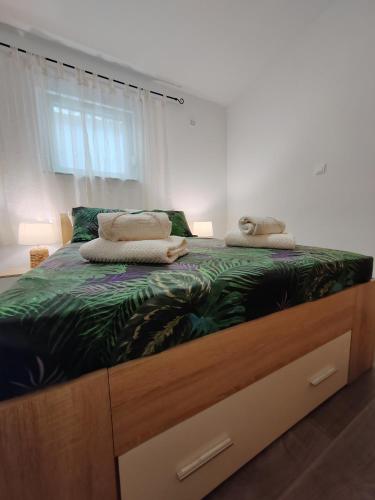 a bed with two pillows on top of it at Apartments and pool Luminous in Pula