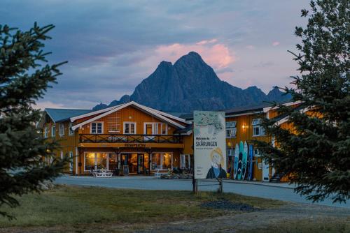 a hotel with a mountain in the background at Skårungen - Hotel, Cabins and Camping in Kabelvåg