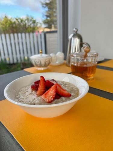 a bowl of oatmeal with strawberries on a table at Ardmorn Holiday Accommodation in Dunvegan