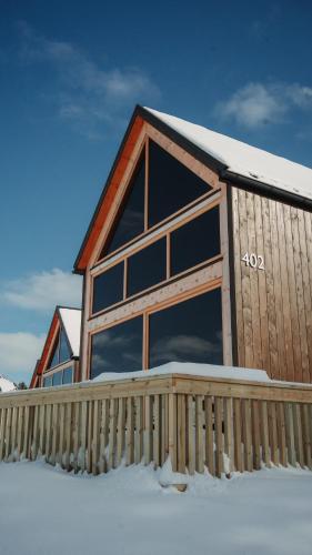a house with a large window in the snow at Skårungen - Hotel, Cabins and Camping in Kabelvåg
