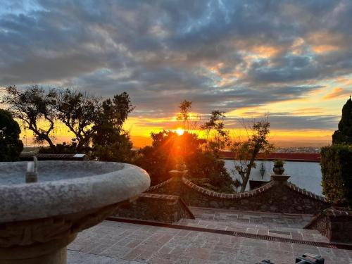 een zonsondergang met zonsondergang in de verte bij suite encanto atardecer in San Miguel de Allende