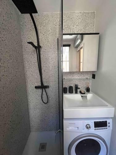- une petite salle de bains pourvue d'un lave-linge et d'un miroir dans l'établissement Appartement d'architecte, Paris-République 2P, à Paris