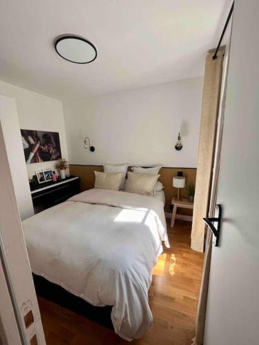 une chambre avec un lit blanc dans une pièce dans l'établissement Appartement d'architecte, Paris-République 2P, à Paris