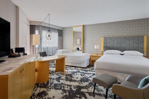 a hotel room with a large bed and a desk at Sheraton Frankfurt Airport Hotel & Conference Center in Frankfurt/Main