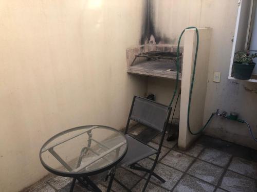 a glass table and a chair in a room at La Casa de Emma in General Roca