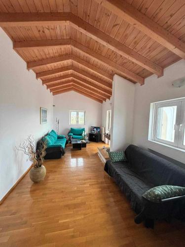 a living room with couches and a wooden ceiling at LOFT HOUSE in Vrahati