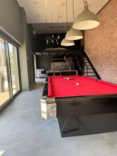 a red pool table in a room with a staircase at The Loft. Gerakas. in Athens