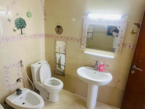 a bathroom with a toilet and a sink at Royal Suite: King Comfort in Ajman 