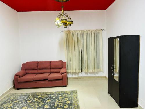 a living room with a couch and a window at Royal Suite: King Comfort in Ajman 