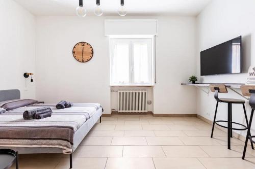 1 dormitorio con 1 cama y reloj en la pared en La Piazzetta, en Piacenza