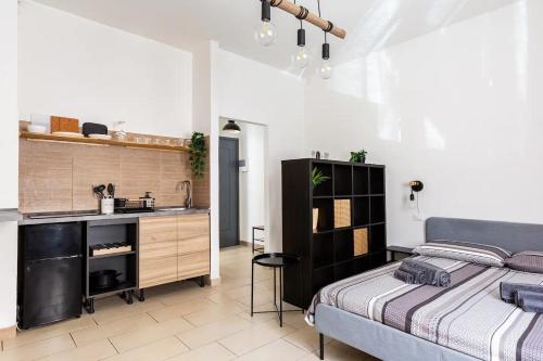 1 dormitorio con 1 cama y lavamanos y cocina en La Piazzetta, en Piacenza