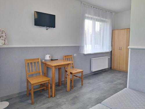 a room with a table and two chairs and a television at Leśne Zacisze in Nickelswalde