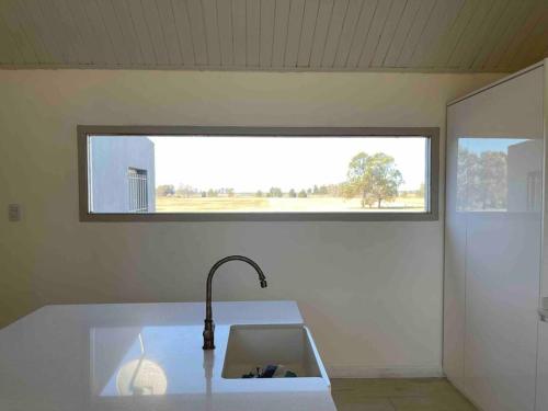 uma cozinha com um lavatório e uma janela em Polo Club Lodge em Lobos