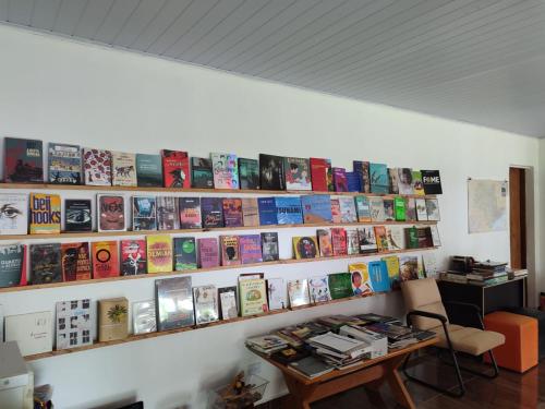 een kamer met een muur gevuld met boeken bij Sítio na Mata Atlântica in Tapiraí