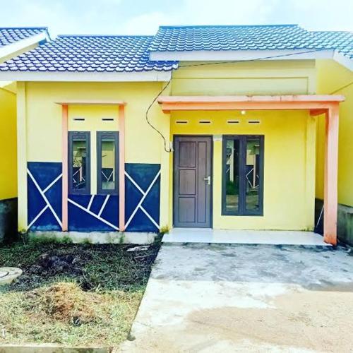 una pequeña casa amarilla y azul con puerta en Rumah PP Supadio en Limbung