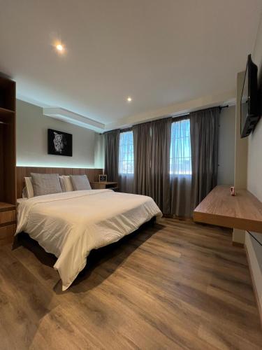 a large bedroom with a large bed and windows at Aerosuites in Bogotá
