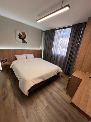 a bedroom with a large bed and a window at Aerosuites in Bogotá