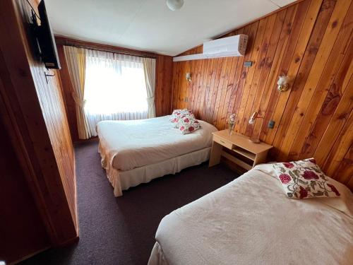 um quarto de hotel com duas camas e uma janela em Hostal Feliza em Valdivia