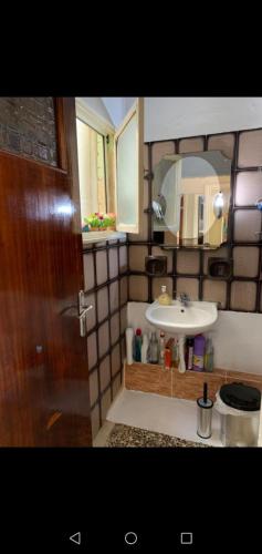 La salle de bains est pourvue d'un lavabo et d'un miroir. dans l'établissement Sunday's Apartment, à Prévéza
