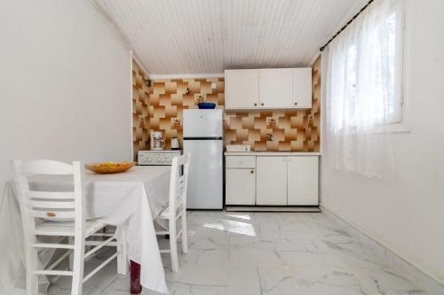 una cucina con tavolo e frigorifero di Blue House a Dafnila