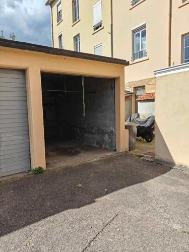 un garage avec sa porte ouverte dans un bâtiment dans l'établissement Superbe studio rénové proche Métro avec garage, à Oullins