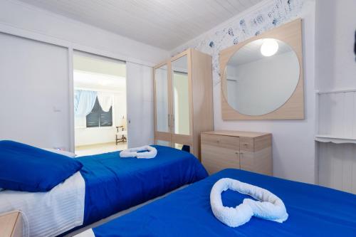 una camera da letto con due letti e uno specchio di Blue House a Dafnila
