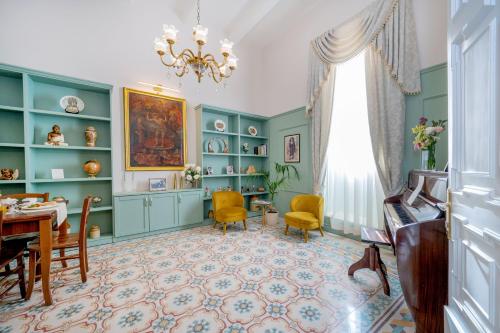 a living room with green cabinets and a table and chairs at Ta' Dun Martin and taz-Zija Bed and Breakfast in Nadur