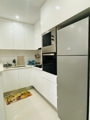a kitchen with white cabinets and a refrigerator at SuAparts in Praia